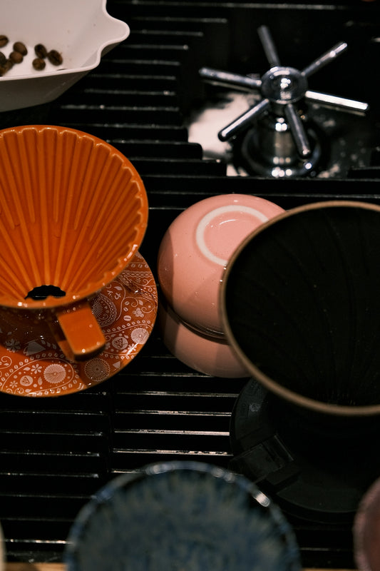 Coffee brewing equipment and cups on a drying rack